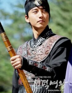 Young warrior in traditional Korean armor holding spear