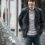 Smiling man walking by glass railing