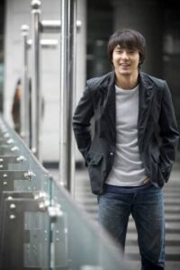 Smiling man walking by glass railing