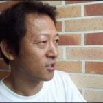 Person in white shirt by brick wall