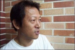 Person in white shirt by brick wall