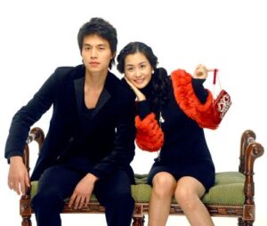 Young couple seated on bench, woman holding purse