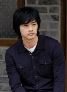 Young man with dark hair wearing navy shirt