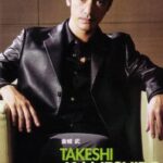 Man in black leather jacket seated in armchair