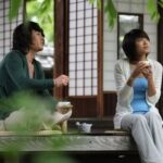 Two people drinking tea on wooden porch