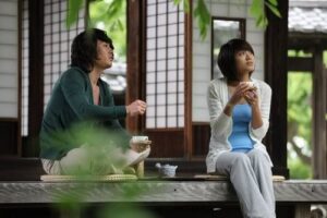 Two people drinking tea on wooden porch