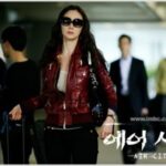 Woman in red jacket with suitcase at airport