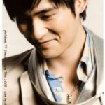 Smiling young man wearing scarf and necklace