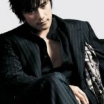 Seated man in dark pinstripe suit, contemplative