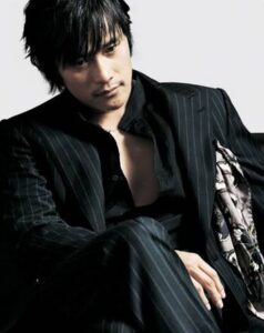 Seated man in dark pinstripe suit, contemplative