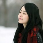 Smiling person wearing red scarf in snow