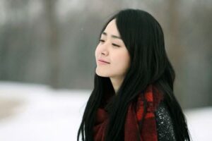 Smiling person wearing red scarf in snow