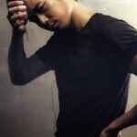 Moody portrait of young man touching forehead
