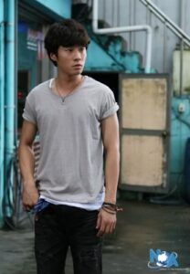 Young man standing in industrial alleyway