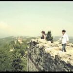 Two people on stone wall overlooking valley