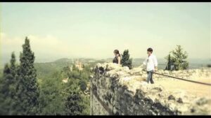 Two people on stone wall overlooking valley