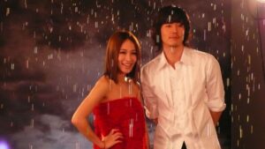 Couple standing in rain, woman in red dress