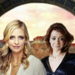 Two women in front of circular stone portal