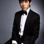 Young man in black tuxedo seated
