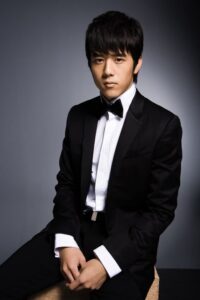 Young man in black tuxedo seated