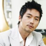 Person in white suit with neutral expression