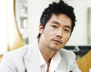 Person in white suit with neutral expression