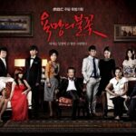 Ensemble cast posed in elegant living room