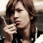 Person pointing while holding an open book