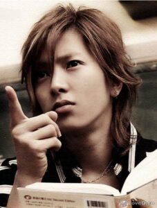 Person pointing while holding an open book