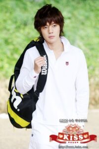 Young man carrying tennis bag in white outfit