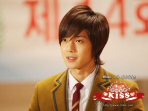 Young man in school uniform speaking at microphone