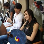 Smiling woman and man seated on sidewalk