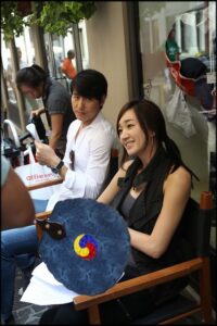 Smiling woman and man seated on sidewalk