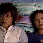 Two people lying side by side on bed