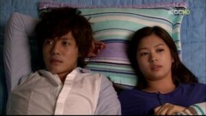 Two people lying side by side on bed