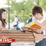 Young man reading book on park bench