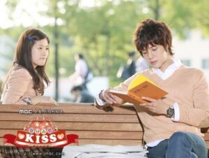 Young man reading book on park bench
