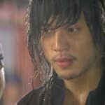 Close-up wet-haired man staring in rain