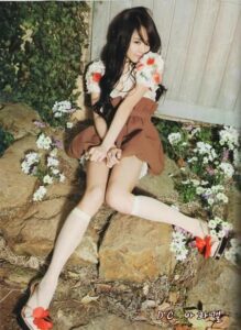 Young woman sitting on rocks among flowers