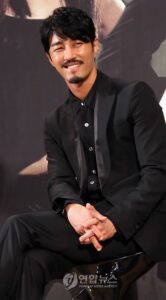 Smiling person seated in black suit