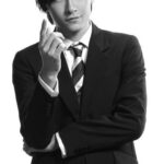 Young man in suit pointing at camera