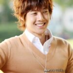 Smiling young man wearing sweater and earphones