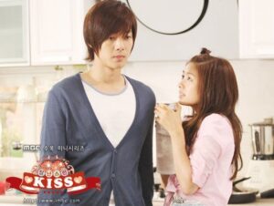 Woman offering drink to serious man in kitchen