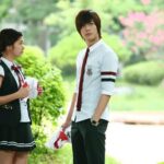 Two students in school uniforms outdoors