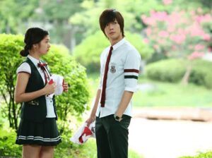 Two students in school uniforms outdoors