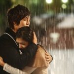 Romantic couple embracing in pouring rain