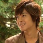 Smiling young man outdoors with trees background