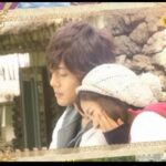 Young couple cuddling outdoors near stone wall