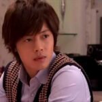 Young man sitting at table wearing vest