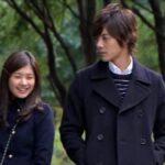 Young couple walking in park, smiling